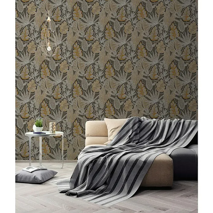 A.S. Création Famous Garden Vliestapete Blatt - Braun-Orange-Weiß, Floral, 10,05 x 0,53 m - Zimmeransicht mit stilvoller Wandtapete mit Pflanzenmuster, Sofa mit Überwurf und Beistelltisch.