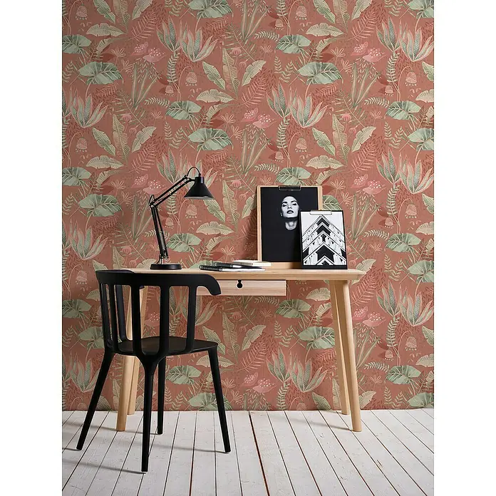A.S. Création Famous Garden Vliestapete - Rot-Orange-Grün, Floral, 10,05 x 0,53 m - Arbeitszimmer mit Schreibtisch, Lampe und Stuhl vor einer Wand mit botanischem Muster.