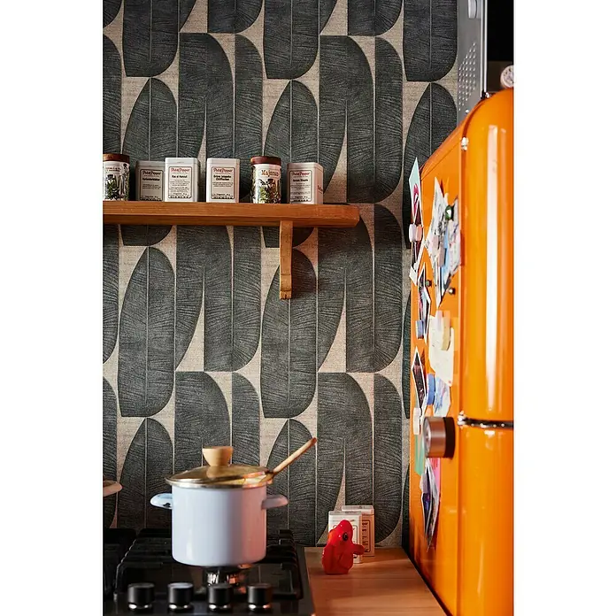 A.S. Création Stories of Life Vliestapete - Beige-Schwarz, Floral, 10,05 x 0,53 m - Küchenszene mit Herd, Topf, Gewürzregal und einem orangefarbenen Kühlschrank, der eine warme und einladende Atmosphäre schafft.