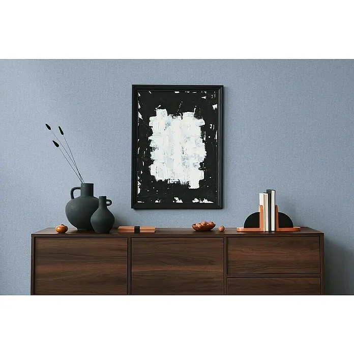 A.S. Création Famous Garden Vliestapete - Blau, Uni, 10,05 x 0,53 m - Nahaufnahme eines Sideboards aus Holz mit Deko-Elementen wie Vasen, einem Kunstwerk und Buchstützen, die eine stilvolle Einrichtung präsentieren.