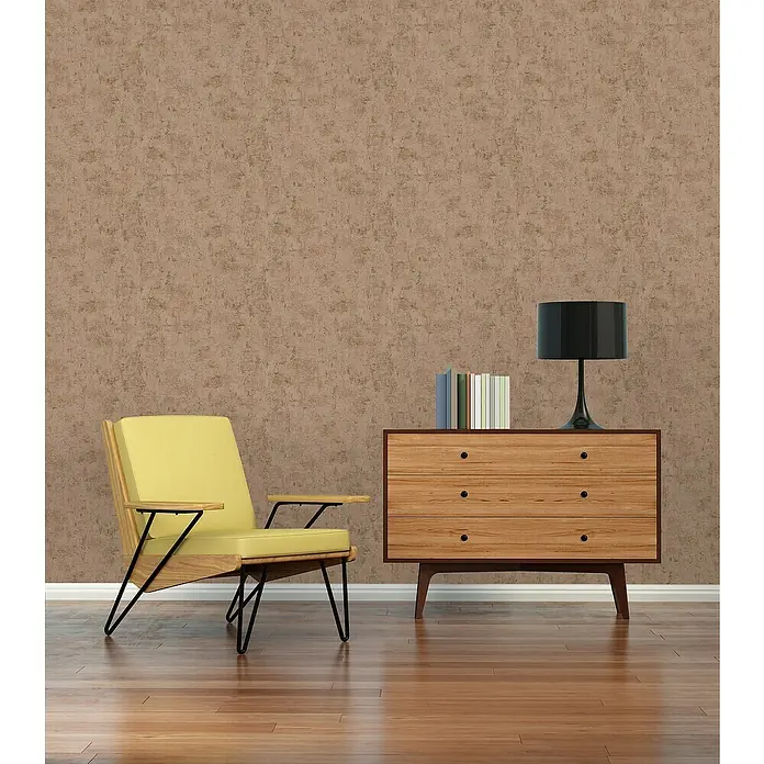 A.S. Création Jade 2 Vliestapete - Rosa-Gold, Uni, 10,05 x 0,53 m - Stilvoller Raum mit gelbem Sessel und Holzkommode mit Lampe und Büchern vor einer strukturierten Wand.