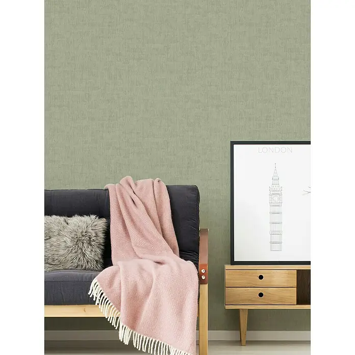 A.S. Création Jade 2 Vliestapete - Grün, Uni, 10,05 x 0,53 m - Stilvolles Interieur mit einem grauen Sofa, einer rosa Decke und einem London-Poster, das eine gemütliche und moderne Atmosphäre schafft.