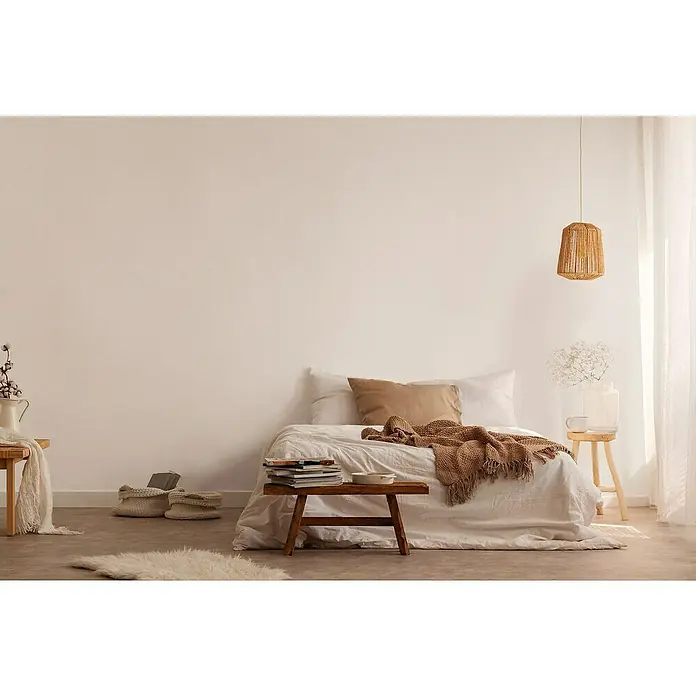 A.S. Création Jade 2 Vliestapete - Creme-Weiß, Uni, 10,05 x 0,53 m - Einladendes Schlafzimmer mit natürlicher Beleuchtung, gemütlichem Bett und dekorativer Hängelampe, die eine entspannende Atmosphäre schafft.