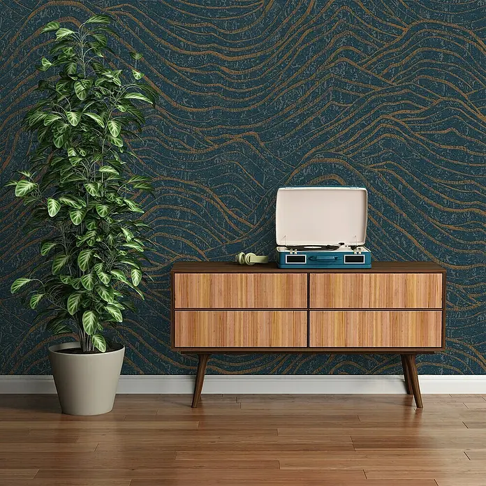 A.S. Création Jade 2 Vliestapete - Dunkelblau-Gold, 3D-Optik, 10,05 x 0,53 m - Aufnahme von Möbeln mit Holzschrank, Schallplattenspieler und Zimmerpflanze vor einer gemusterten Wand.