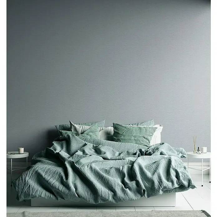 A.S. Création Famous Garden Vliestapete - Grau-Hellgrau, Uni, 10,05 x 0,53 m - Bett mit mintfarbener Bettwäsche und Kissen. Die Textur des Stoffes ist weich und einladend, perfekt für eine entspannte Schlafumgebung.