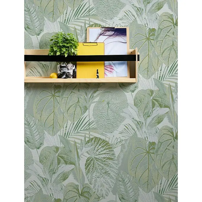 A.S. Création Famous Garden Vliestapete Dschungel - Grün-Weiß-Grau, Floral, 10,05 x 0,53 m - Wandregal mit Pflanzen, Ordnern und Fotos vor einer grünen Blättertapete, die dem Raum eine natürliche Note verleiht.