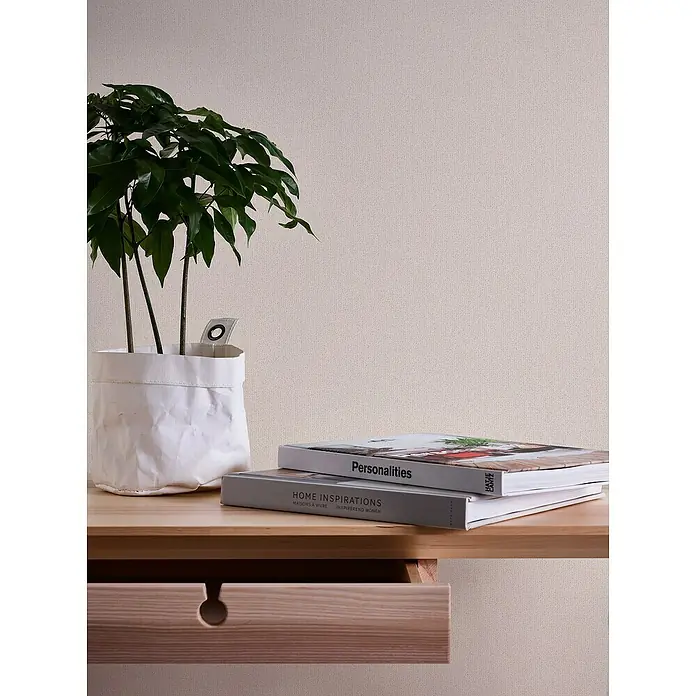 A.S. Création Jade 2 Vliestapete - Beige-Creme, Uni, 10,05 x 0,53 m - Stillleben mit einer Zimmerpflanze in einem weißen Papierbeutel, zwei Büchern und einem hölzernen Nachttisch mit Schublade.