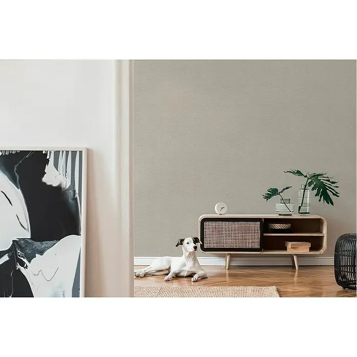 A.S. Création Famous Garden Vliestapete - Taupe, Uni, 10,05 x 0,53 m - Stilvolles Wohnzimmer mit einem Holzschrank, auf dem Dekorationen stehen und ein Hund davor liegt, der dem Raum eine gemütliche Note verleiht.