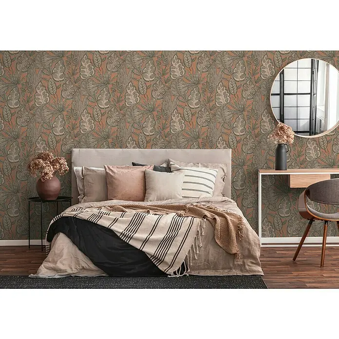 A.S. Création Famous Garden Vliestapete Blatt - Rosa-Grau-Taupe, Floral, 10,05 x 0,53 m - Ein Schlafzimmer mit einer floralen Tapete in Braun- und Beigetönen, mit einem Bett mit vielen Kissen und einem gestreiften Überwurf.