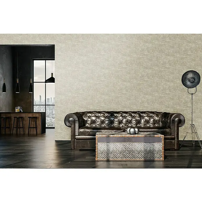 A.S. Création Stories of Life Vliestapete - Beige-Weiß-Gold, Uni, 10,05 x 0,53 m - Braunes Ledersofa im Wohnzimmer mit industriellem Couchtisch und Stehlampe. Zeitgenössisches Interieur mit Bar im Hintergrund.