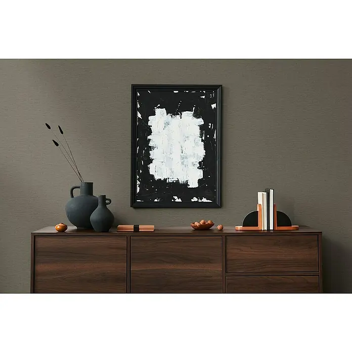 A.S. Création Famous Garden Vliestapete - Braun, Uni, 10,05 x 0,53 m - Modernes Wohnzimmer mit einer Kommode aus dunklem Holz, darauf eine Vase, ein Bild und Buchstützen.