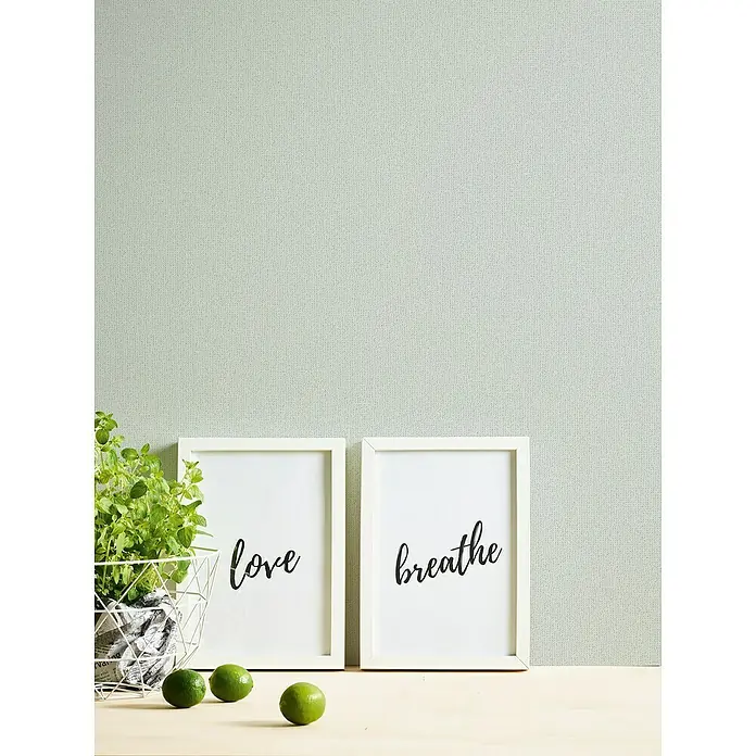 A.S. Création Jade 2 Vliestapete - Mintgrün, Uni, 10,05 x 0,53 m - Dekoratives Bild mit den Aufschriften "Love" und "Breathe", flankiert von einem Pflanzkorb und frischen Limetten, die eine entspannende Atmosphäre schaffen.