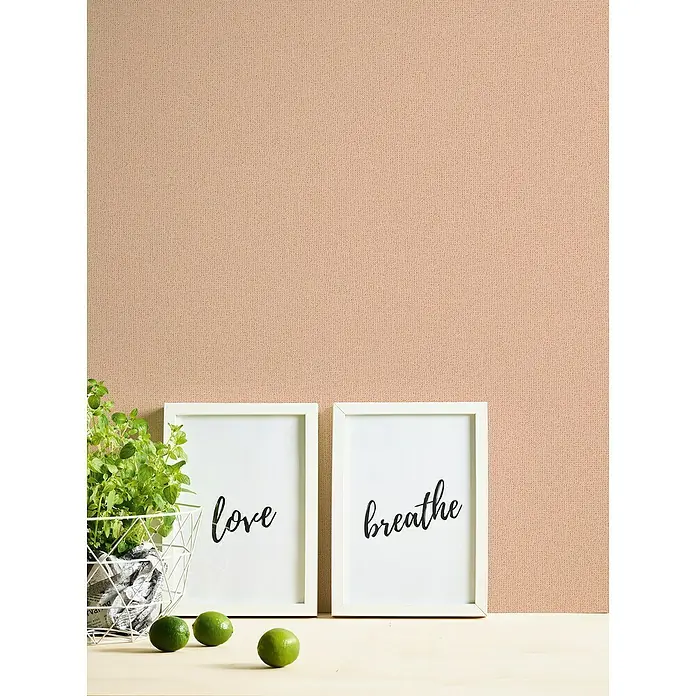 A.S. Création Jade 2 Vliestapete - Rosa-Orange, Uni, 10,05 x 0,53 m - Zwei gerahmte Bilder mit den Aufschriften "Love" und "Breathe" zusammen mit einer Pflanze und Limetten auf einem Tisch vor einer rosa Wand.