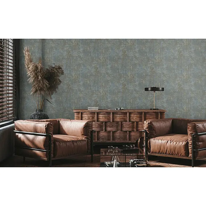 A.S. Création Stories of Life Vliestapete Patina - Braun-Blau-Gold, Betonoptik, 10,05 x 0,53 m - Wohnzimmer-Interieur mit zwei Ledersesseln, einem Holzschrank und dekorativen Elementen, die eine gemütliche Atmosphäre schaffen.