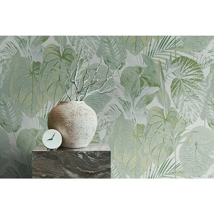 A.S. Création Famous Garden Vliestapete Dschungel - Grün-Weiß-Grau, Floral, 10,05 x 0,53 m - Nahaufnahme eines Dekorationsobjekts mit Vase, Ästen und einer kleinen Uhr vor einem Hintergrund mit tropischen Blättern.
