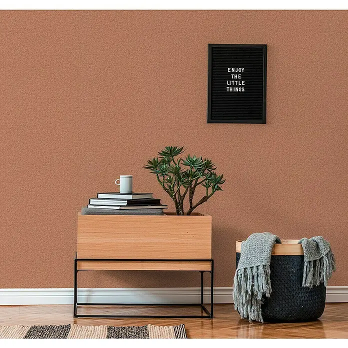 A.S. Création Famous Garden Vliestapete - Rot-Orange, Uni, 10,05 x 0,53 m - Einrichtungsidee: Holzpflanzkasten mit Bücherstapel, Tasse, Sukkulente, Korb mit Tuch und Spruchtafel vor brauner Wand.