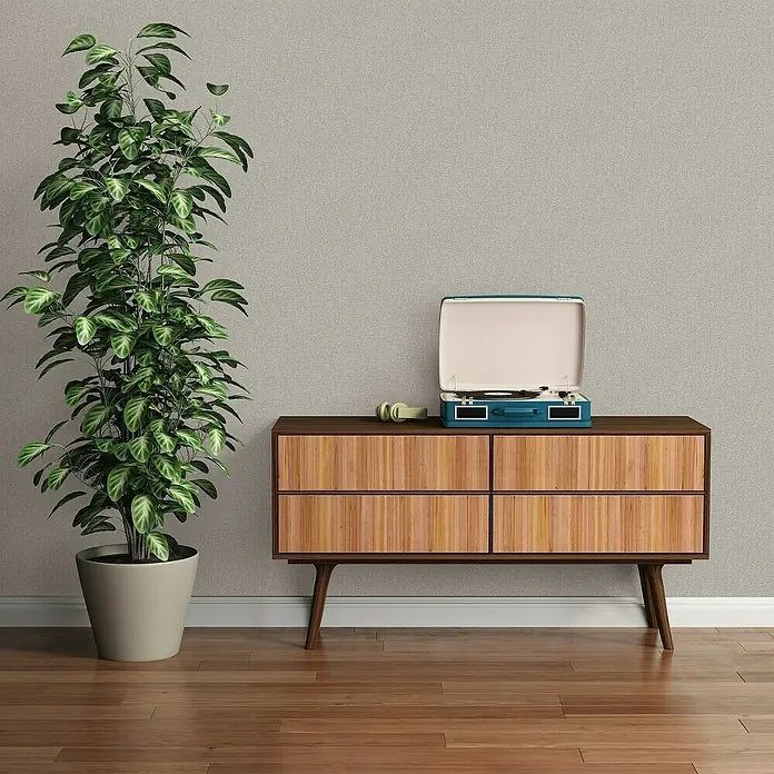 A.S. Création Famous Garden Vliestapete - Grau, Uni, 10,05 x 0,53 m - Ein Retro-Plattenspieler in Türkis steht auf einem Holzschrank, daneben eine große Zimmerpflanze. Die Szene wirkt wohnlich und stilvoll.
