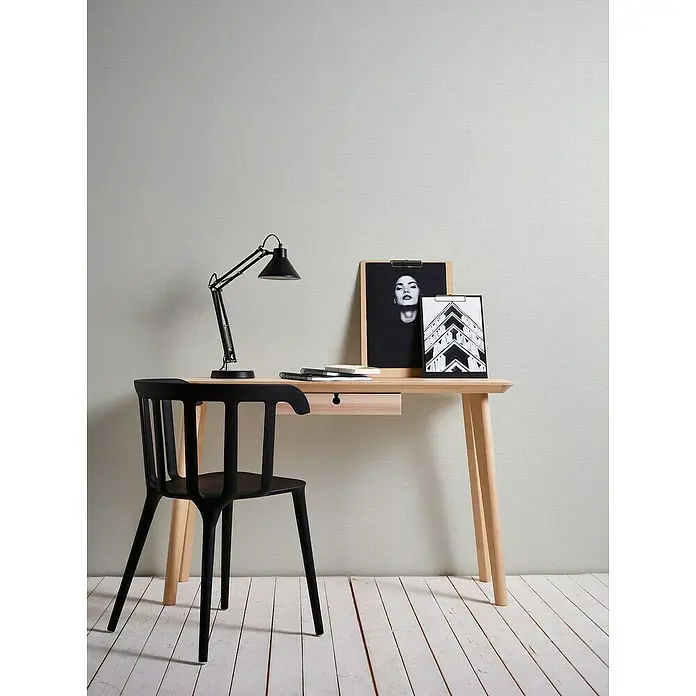 A.S. Création Famous Garden Vliestapete - Grau-Weiß, Uni, 10,05 x 0,53 m - Ein heller Schreibtisch mit schwarzer Lampe, Stuhl und dekorativen Bildern. Das minimalistische Design passt gut in moderne Büros oder Arbeitszimmer.