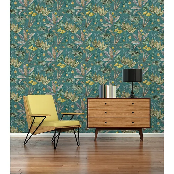 A.S. Création Famous Garden Vliestapete - Petrol-Grün-Gelb, Floral, 10,05 x 0,53 m - Einrichtungsidee mit einem gelben Sessel und einer Holzkommode vor einer blumigen Tapete. Moderne Möbel treffen auf klassische Muster.