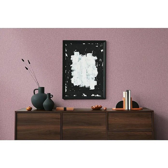 A.S. Création Famous Garden Vliestapete - Violett-Pink, Uni, 10,05 x 0,53 m - Ein Sideboard aus dunklem Holz mit minimalistischem Dekor, darunter Vasen, ein abstraktes Gemälde und dekorative Buchstützen.