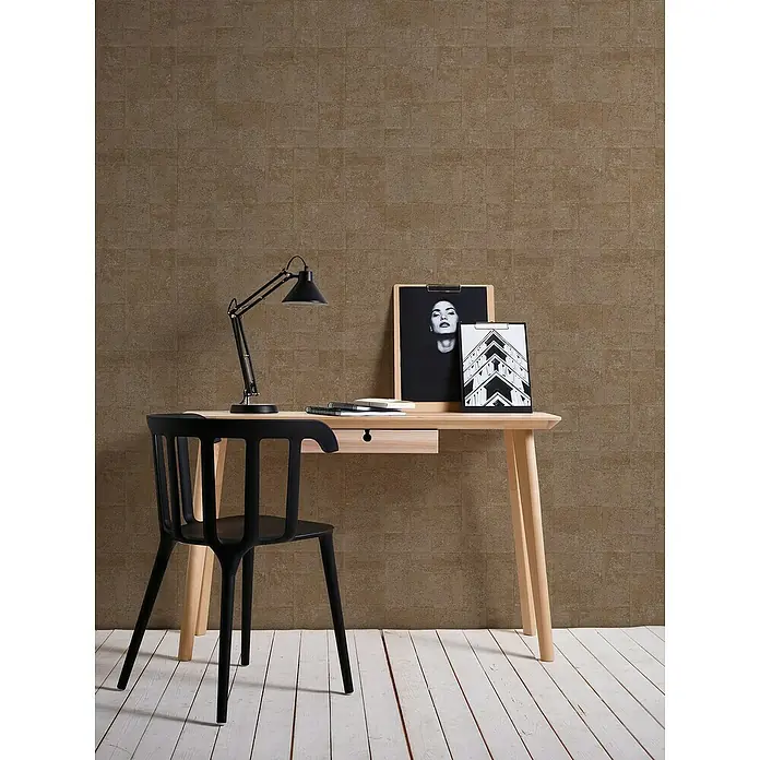 A.S. Création Stories of Life Vliestapete - Gold-Taupe, Grafisch, 10,05 x 0,53 m - Ein stilvoller Schreibtisch mit einer schwarzen Lampe, einer Ablage und einem schwarzen Stuhl vor einer strukturierten Wand.