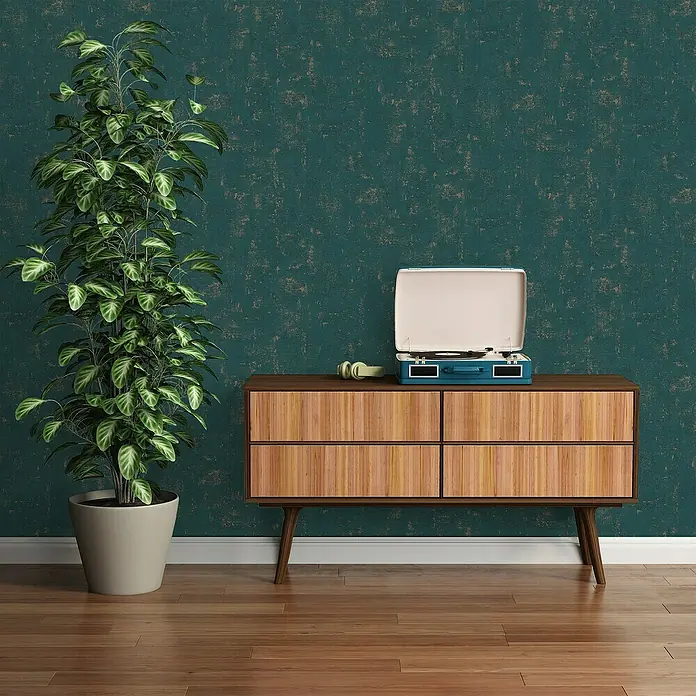 A.S. Création Jade 2 Vliestapete - Petrol-Gold, Uni, 10,05 x 0,53 m - Elegantes Interieur mit einem Plattenspieler auf einer Holzkommode, einer Zimmerpflanze und einer grünen Wand mit Textur.