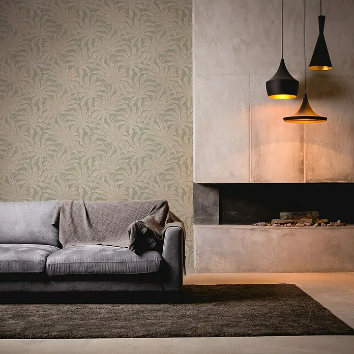 A.S. Création Jade 2 Vliestapete Pflanzen - Grün-Gold-Silber, Floral, 10,05 x 0,53 m - Elegantes Wohnzimmer mit einem stilvollen Sofa, gemusterter Tapete und modernen Pendelleuchten, die eine warme Atmosphäre schaffen.
