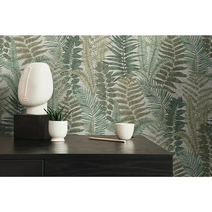 A.S. Création Famous Garden Vliestapete - Beige-Grün-Braun, Floral, 10,05 x 0,53 m - Nahaufnahme eines stilvollen schwarzen Tisches mit einer modernen weißen Skulptur und Topfpflanze vor einer grünen Blättertapete.
