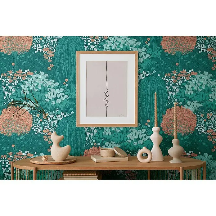 A.S. Création Famous Garden Vliestapete - Petrol-Orange-Grün, Floral, 10,05 x 0,53 m - Die Illustration zeigt ein abstraktes Kunstwerk in einem Holzrahmen, das an einer floralen Tapete hängt, mit dekorativen Elementen auf einem Holztisch.