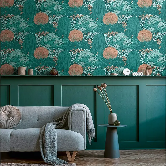 A.S. Création Famous Garden Vliestapete - Petrol-Orange-Grün, Floral, 10,05 x 0,53 m - Ein elegantes Wohnzimmer mit einer grauen Couch, einem Beistelltisch und einer Wand mit floralem Muster.