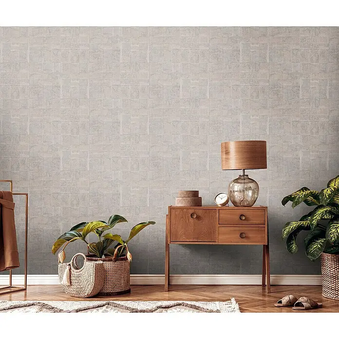 A.S. Création Stories of Life Vliestapete - Gold-Grau Metallic, Grafisch, 10,05 x 0,53 m - Stilvolles Interieur mit einer Kommode aus Holz, einer Lampe und Pflanzen. Die Tapete hat ein dezentes Steinmuster.