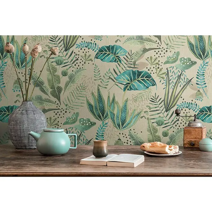 A.S. Création Famous Garden Vliestapete - Beige-Grün-Blau, Floral, 10,05 x 0,53 m - Stillleben mit einer Teekanne, einer Kaffeemühle und einem Buch auf einem Holztisch vor einer floralen Tapete.