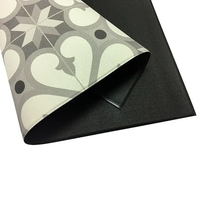 Alfombra de vinilo Croma Hidra topo - 180 x 120 cm - Primer plano de una alfombra decorativa con un patrón gris y un reverso negro.