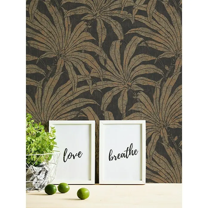 A.S. Création Jade 2 Vliestapete Pflanzen - Schwarz-Gold-Bronze, Floral, 10,05 x 0,53 m - Nahaufnahme von zwei weißen Bilderrahmen mit den Aufschriften "love" und "breathe" vor einer botanischen Tapete.