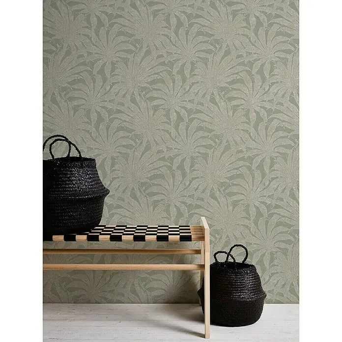A.S. Création Jade 2 Vliestapete Pflanzen - Grün-Gold-Silber, Floral, 10,05 x 0,53 m - Eine Bank mit zwei schwarzen Körben vor einer Wand mit Blättermuster-Tapete.
