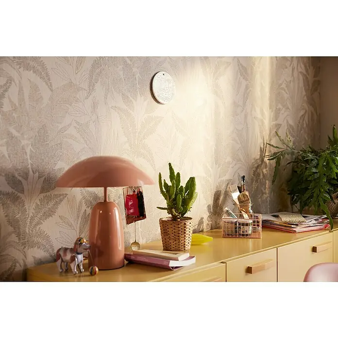 A.S. Création Stories of Life Vliestapete Dschungel - Beige-Gold, Floral, 10,05 x 0,53 m - Ein skurriler Nachttisch mit einer zartrosa Lampe, einem Kaktus im Korb und einer verspielten Hunde-Figur, die Charme versprühen.