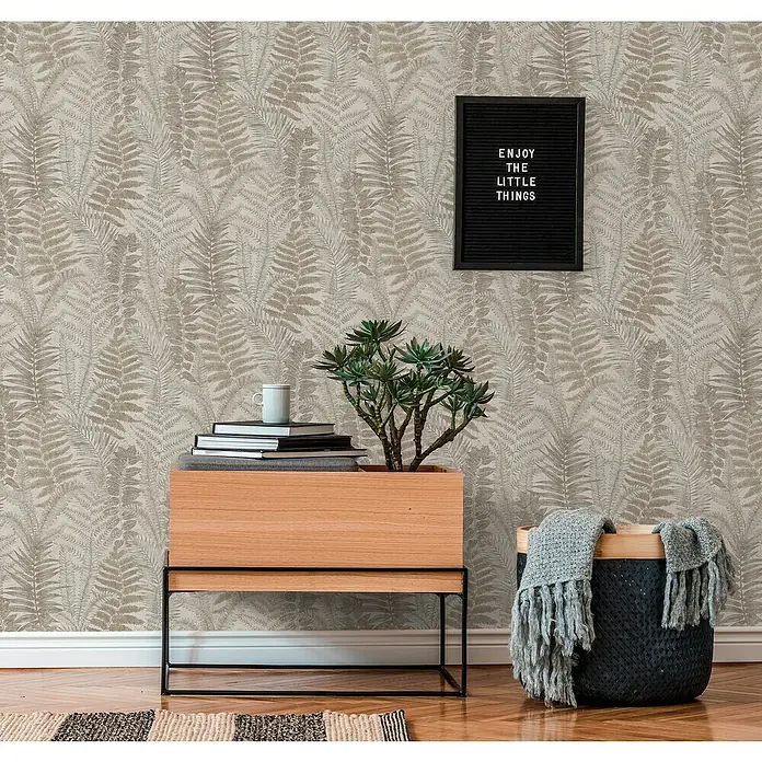 A.S. Création Famous Garden Vliestapete - Grau-Beige-Taupe, Floral, 10,05 x 0,53 m - Nahaufnahme eines dekorierten Raumes mit Holzbeistelltisch, Zimmerpflanze, Büchern, Korb und einer Wandtafel mit der Aufschrift "Enjoy the Little Things".