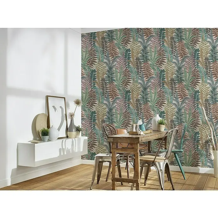 A.S. Création Famous Garden Vliestapete - Bunt-Beige-Grün, Floral, 10,05 x 0,53 m - Nahaufnahme eines Raumes mit einer Akzentwand mit Blattmuster-Tapete, einem Holztisch und einem weißen Regal.