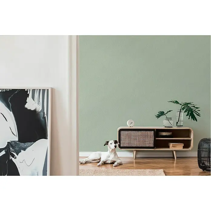 A.S. Création Famous Garden Vliestapete - Grün, Uni, 10,05 x 0,53 m - Heller Raum mit modernem Sideboard aus Holz, einer Pflanze und einem Jack Russell Terrier. Ideale Aufbewahrung und Dekoration für das Wohnzimmer.