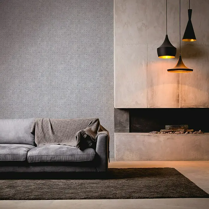 A.S. Création Stories of Life Vliestapete Used-Look - Lilagrau-Silber, Betonoptik, 10,05 x 0,53 m - Wohnzimmer mit Sofa, Teppich und drei schwarzen Hängelampen über dem Kamin, die warmes Licht spenden. Stilvolles Interieur.