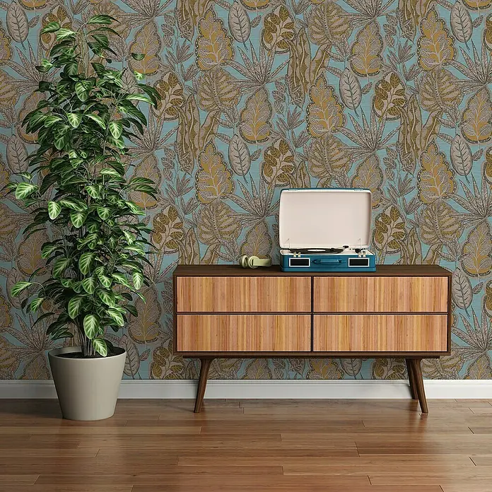 A.S. Création Famous Garden Vliestapete Blatt - Hellblau-Gelb-Braun, Floral, 10,05 x 0,53 m - Aufnahme einer hölzernen Kommode mit Schallplattenspieler und Kopfhörern, ergänzt durch eine Zimmerpflanze vor einer gemusterten Tapete.