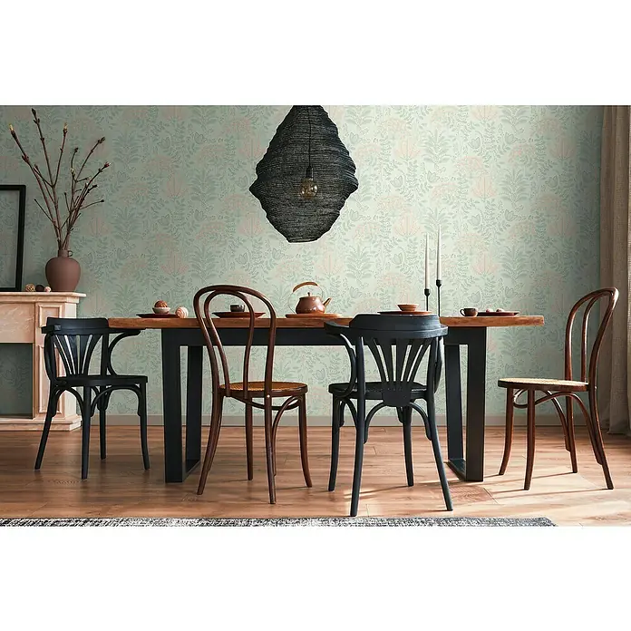 A.S. Création Famous Garden Vliestapete - Grün-Grau-Rosa, Floral, 10,05 x 0,53 m - Ein Esszimmer mit einem Holztisch, schwarzen und braunen Stühlen, einer auffälligen Lampe und gemusterter Tapete.