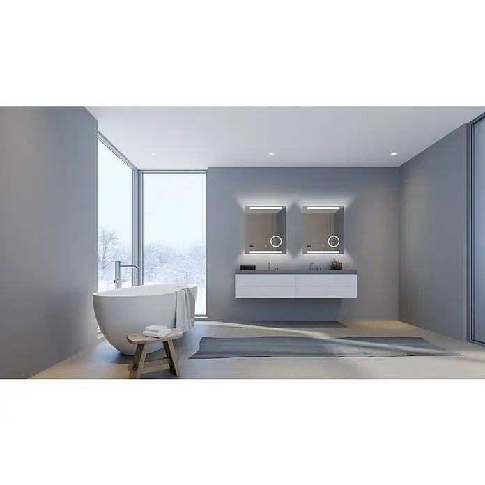 DSK Lichtspiegel Silver Rey - 60 x 70 cm, Silber, Leuchtmittel - Elegantes Badezimmer mit freistehender Badewanne und zwei beleuchteten Spiegeln über einem modernen Waschtisch. Das Fenster bietet einen Winterblick.