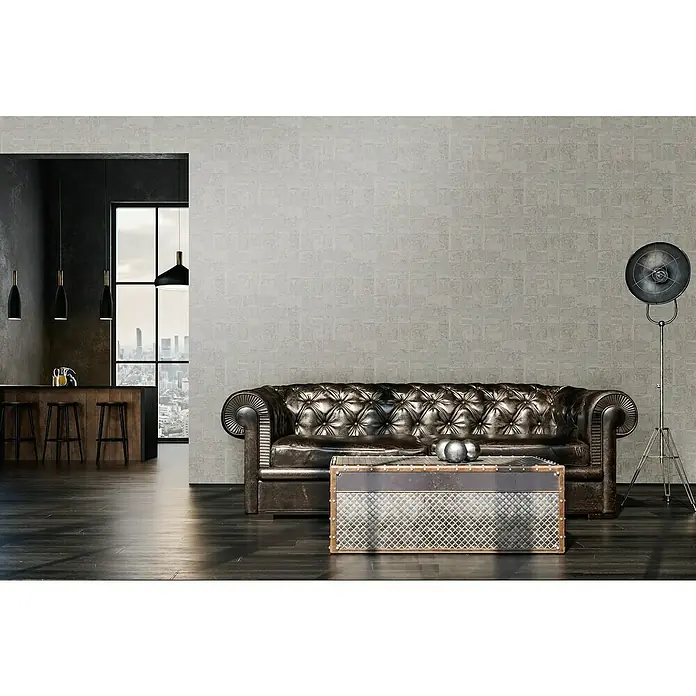 A.S. Création Stories of Life Vliestapete - Silbergrau, Grafisch, 10,05 x 0,53 m - Edles Interieur mit braunem Chesterfield-Sofa, dekorativem Couchtisch und stilvoller Stehlampe vor einer strukturierten Wand.