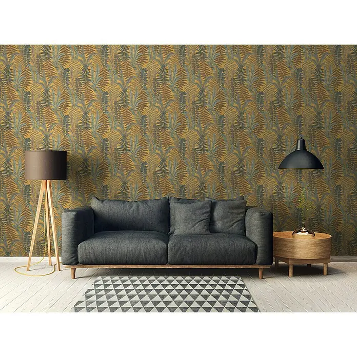 A.S. Création Famous Garden Vliestapete - Gelb-Blau-Braun, Floral, 10,05 x 0,53 m - Ein stilvolles Wohnzimmer mit einem grauen Sofa, einer Stehlampe und einem runden Beistelltisch vor einer auffälligen Blättertapete.