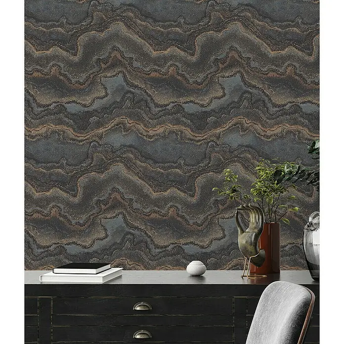 A.S. Création Stories of Life Vliestapete Marmoroptik Metallic-Effekt - Schwarz-Gold, Steinoptik, 10,05 x 0,53 m - Nahaufnahme einer Wand mit dem auffälligen "Maluku"-Tapetenmuster, das sich durch geschwungene Linien in Grau- und Brauntönen auszeichnet.