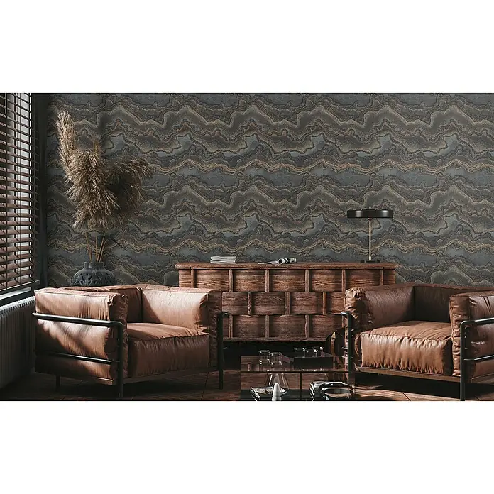 A.S. Création Stories of Life Vliestapete Marmoroptik Metallic-Effekt - Schwarz-Gold, Steinoptik, 10,05 x 0,53 m - Wohnzimmer mit zwei braunen Ledersesseln und einem Holztisch. Die Wand ist mit einer grauen Tapete mit Marmormuster verziert.