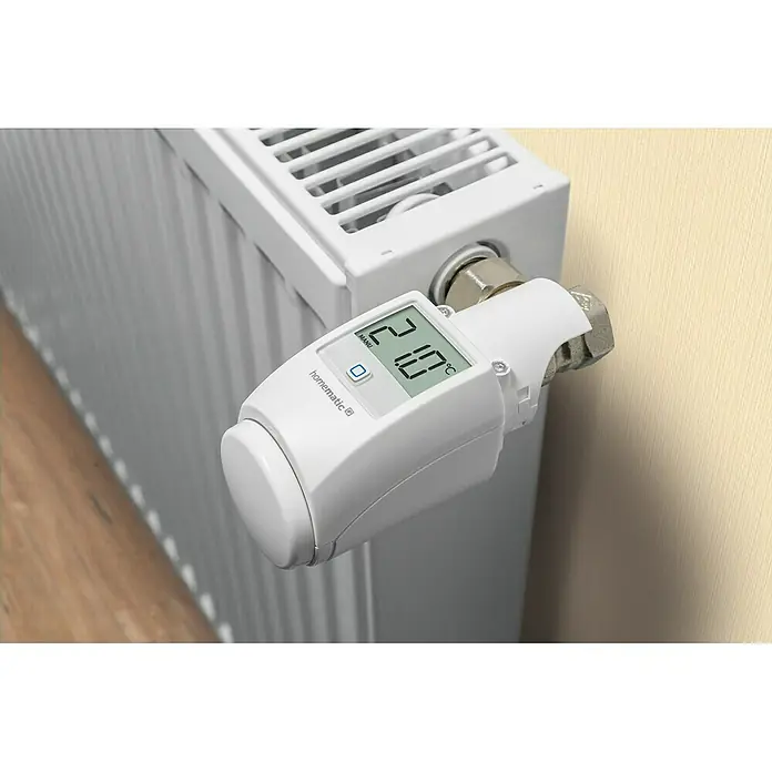 Homematic IP Diebstahlsicherung für Heizkörperthermostate - L x B x H: 46 x 23 x 46 mm - Nahaufnahme eines Homematic IP Heizkörperthermostats mit LCD-Display und Bedienknopf am Heizkörper.