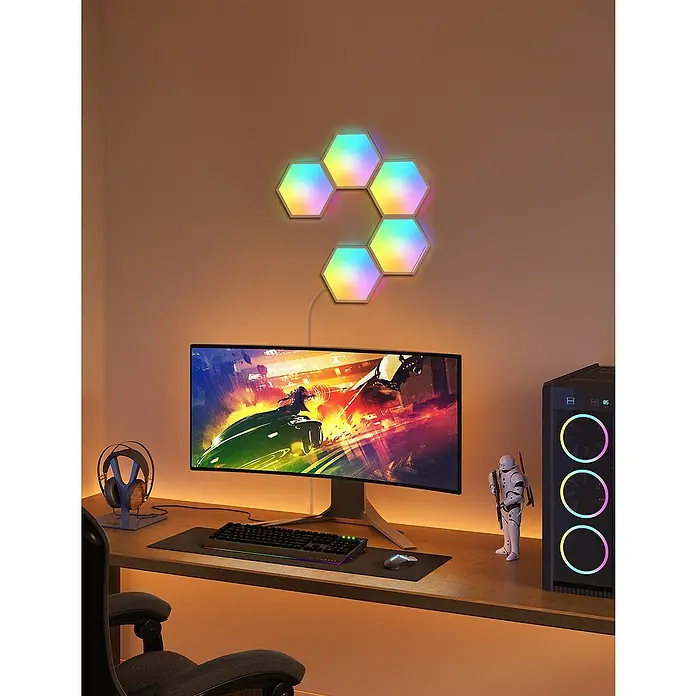 Govee Starterkit Glide Hexa Light Panels B6061 - Weiß - Gaming-Setup mit einem Curved Monitor, einer Tastatur, einer Maus und LED-Panels an der Wand für eine stimmungsvolle Beleuchtung.