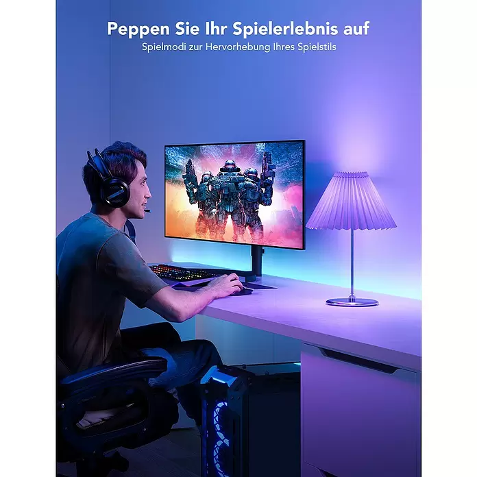 Govee Smart-LED-Lampe H6009 - E27, Dimmbar, RGBW, 1.200 lm, 12 W - Ein Gamer mit Headset spielt an einem Monitor, umgeben von lebendiger RGB-Beleuchtung von PC und Lampe, für ein intensives Erlebnis.